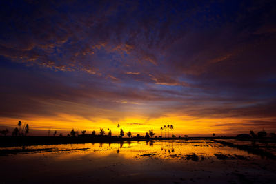 Scenic view of silhouette city against sky during sunset