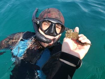 High angle portrait of man holding seahorse during scuba diving