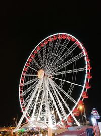 Low angle view of illuminated ferris wheel against sky at night