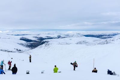 People on snowcapped mountain during winter