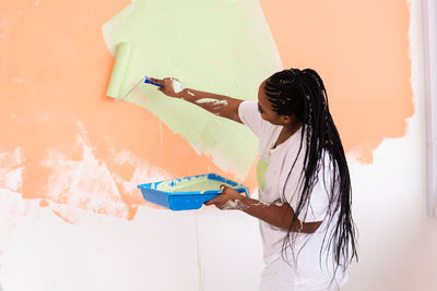 Side view of woman standing against wall