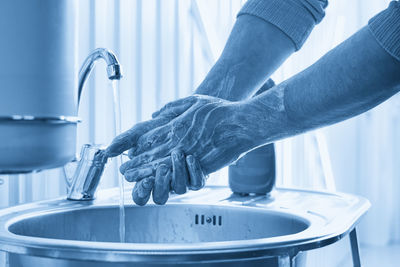 Low section of person washing hands