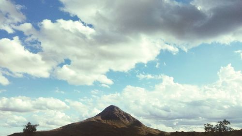 Low angle view of mountain against cloudy sky