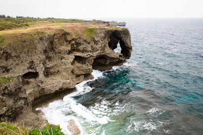 Rock formation in sea against sky