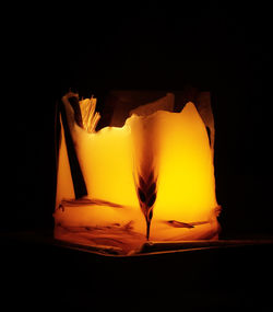 Close-up of yellow candle in darkroom