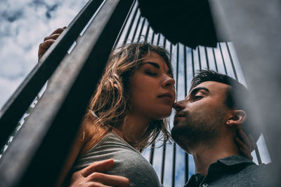 Portrait of young couple in cage low angle