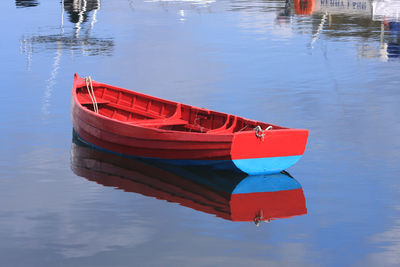 Red boat moored in water