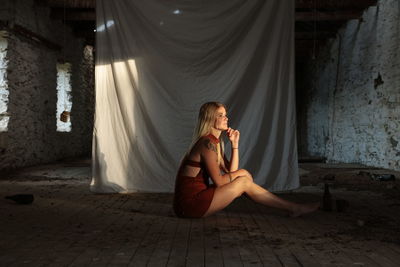 Young woman sitting on floor at home