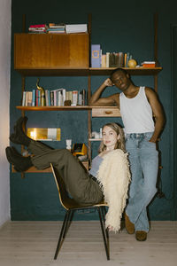 Portrait of multiracial friends posing near shelf at home