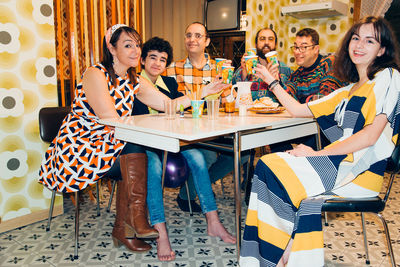 Portrait of family toasting drinks at dining table