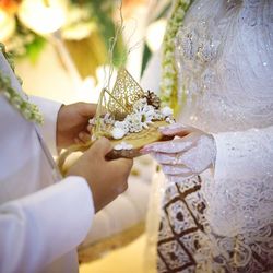 Midsection of couple holding wedding rings