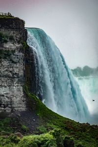 Scenic view of waterfall against sky