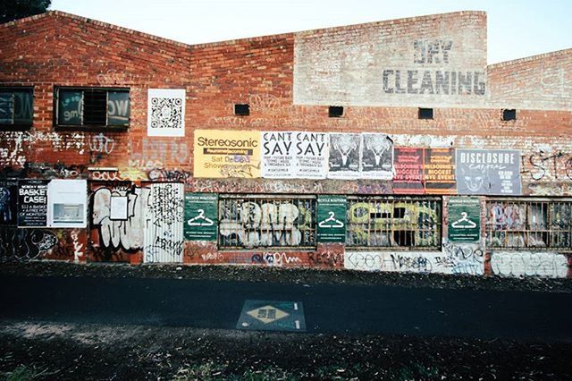 architecture, built structure, building exterior, graffiti, text, western script, communication, wall - building feature, building, window, capital letter, day, outdoors, city, non-western script, brick wall, street, residential building, no people, abandoned