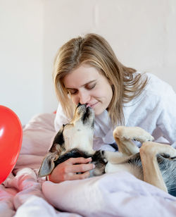 Portrait of young woman holding dog