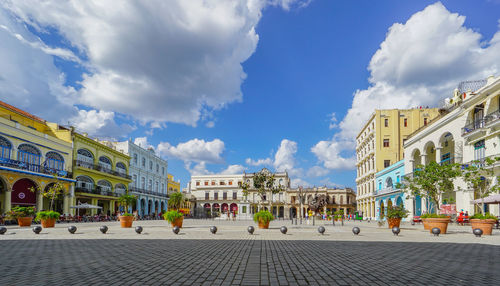 Buildings in city against cloudy sky