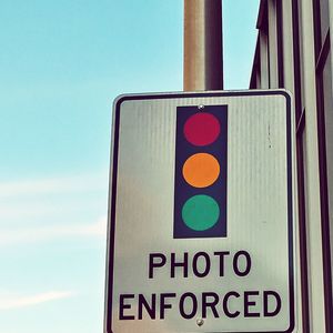 Low angle view of road sign against sky