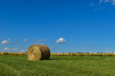 Hay bales on field against sky