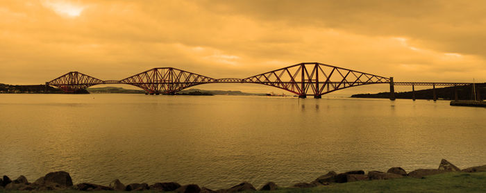 View of bridge over river at sunset