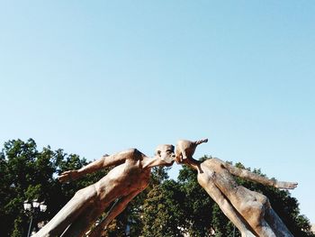 Low angle view of man sculpture against clear sky