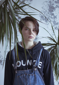 Portrait of young man standing against trees