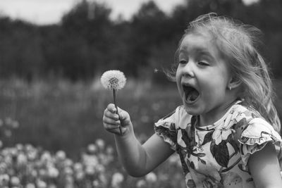 Portrait of cute girl holding dandelion