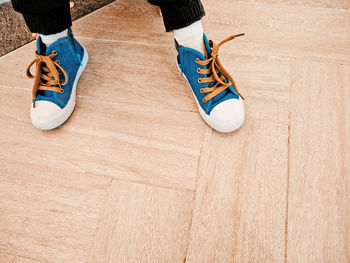 Low section of woman standing on hardwood floor