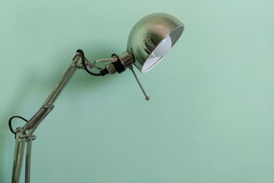 Close-up of table lamp against green wall