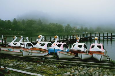 Boats moored in lake against sky