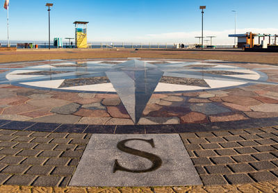 Arrow sign on footpath in city