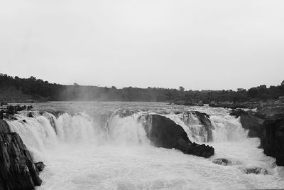 Scenic view of waterfall against sky