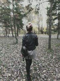 Rear view of woman walking in forest