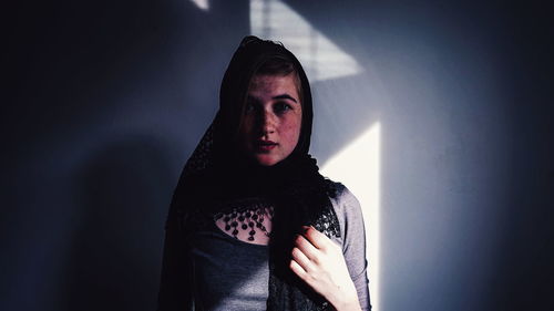 Close-up of young woman standing against wall