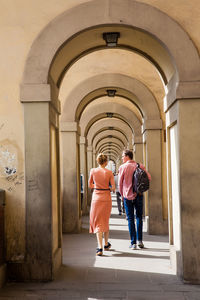 Rear view of people walking in corridor of building