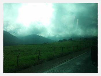 Country road against cloudy sky