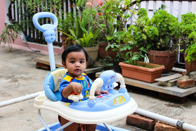 Portrait of cute boy standing in baby walker