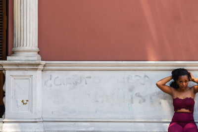 Portrait of woman standing against wall