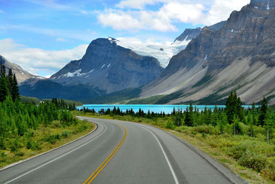 Road by mountains against sky