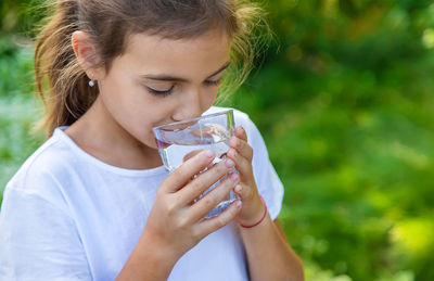 Girl drinking water outdoors