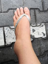 Low section of woman legs on footpath