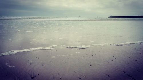 Close-up of sand on beach against sky