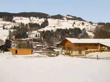 Built structure on snow covered landscape against sky