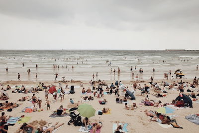 Group of people on beach against sky