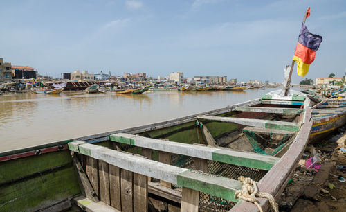 Boats moored in city against sky