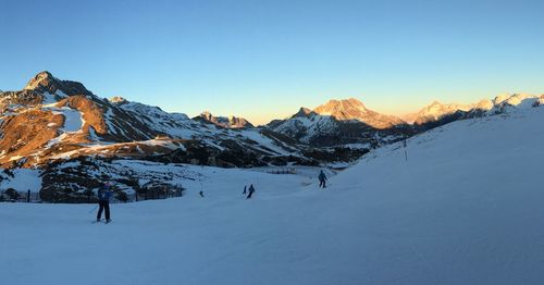 People skiing on snow covered field