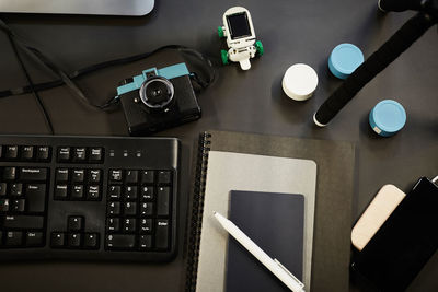 Directly above shot of various technologies and diaries on desk in office