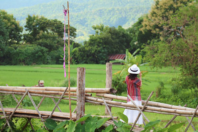 Full length of woman wearing hat on field