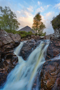 Scenic view of waterfall against sky