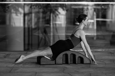 Side view of woman sitting on floor