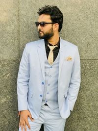 Young man standing against wall