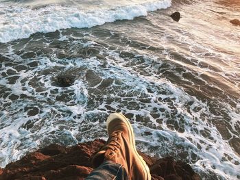 Low section of person on rock in sea